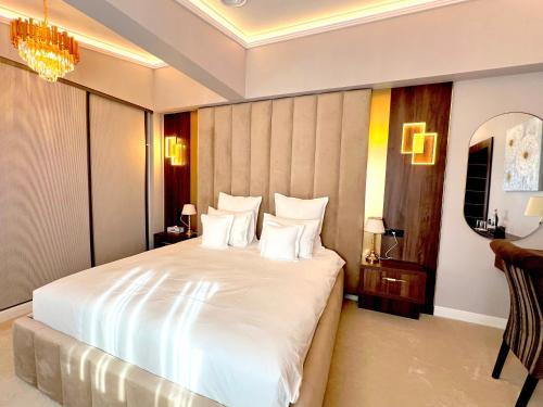 a bedroom with a large white bed with white pillows at Hotel 5 Continents in Craiova