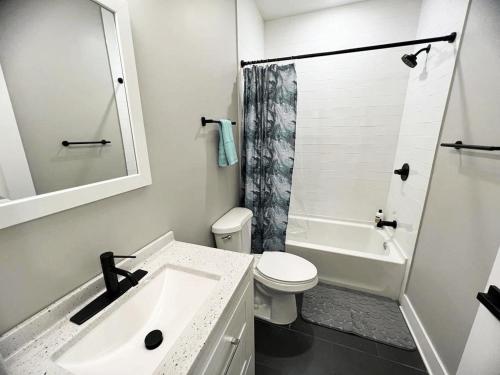 a white bathroom with a sink and a toilet at Modern 2BR 2BA Apartment with rooftop in Brewerytown in Philadelphia