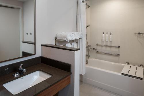 a bathroom with a sink and a bath tub at Fairfield by Marriott Inn & Suites Huntsville Redstone Gateway in Huntsville