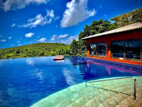 une grande piscine à côté d'un bâtiment rouge dans l'établissement Villas do Pratagy VIP, à Maceió