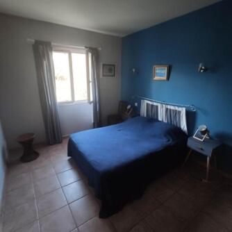 - une chambre bleue avec un lit et une fenêtre dans l'établissement Villa E case di u Puntale, à Ghisonaccia