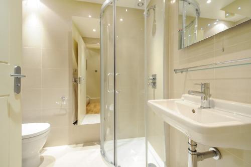 a bathroom with a shower and a sink and a toilet at Georgiana's Guesthouse in London