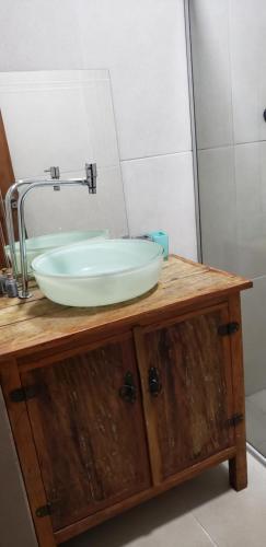 uma casa de banho com um lavatório num toucador de madeira em Casa verde em Campo Grande