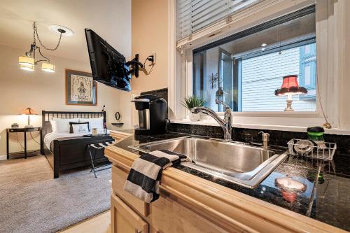 uma cozinha com um lavatório e uma televisão num quarto em The Orenco em Hillsboro