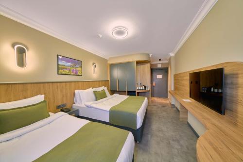 a hotel room with two beds and a flat screen tv at Rest by Dedeman Karabük in Karabük