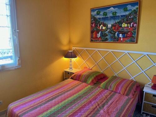 une chambre avec un lit et un tableau au mur dans l'établissement Appartement T2 avec Terrasse, Parking Privé et Piscine Sécurisée, Proche Plage Richelieu - FR-1-749-37, au Cap d'Agde