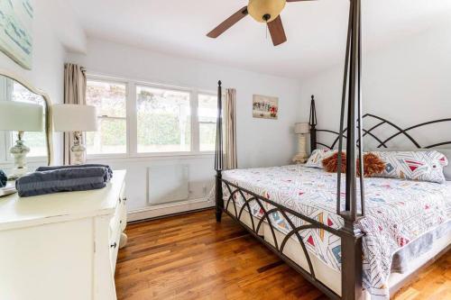 グリーンポートにあるGreenport village cottage w/ 4 bedroomsのベッドルーム1室(ベッド1台、シーリングファン付)