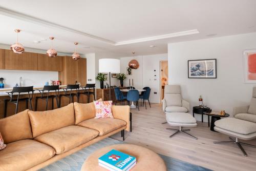 a living room with a couch and a kitchen at Four The Reach in Salcombe