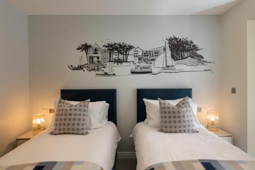 two beds sitting next to each other in a bedroom at Four The Reach in Salcombe