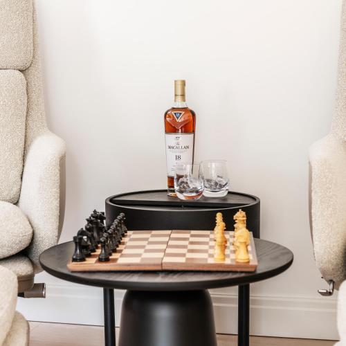 a bottle of whiskey and chessboard on a table at Four The Reach in Salcombe