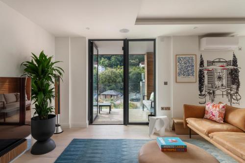 a living room with a couch and a plant at Four The Reach in Salcombe