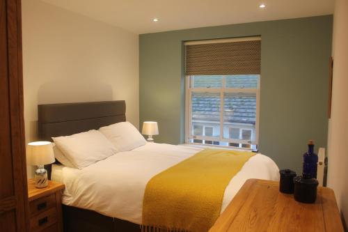 a bedroom with a large bed and a window at Stylish flat in central Tenby & free parking in Tenby