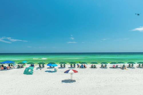 eine Gruppe von Sonnenschirmen und Stühlen am Strand in der Unterkunft Destin On The Gulf 505 Condo in Destin