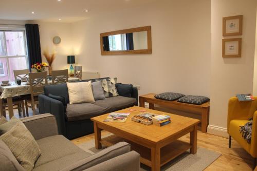 a living room with couches and a table at Stylish flat in central Tenby & free parking in Tenby