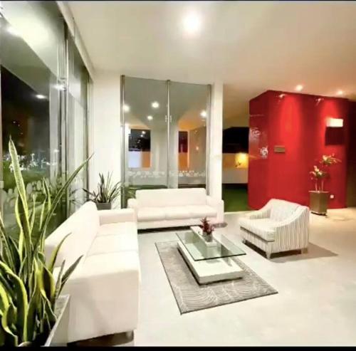 a living room with white furniture and a red cabinet at Apartaestudio Jacuzzi Centro Comercial Gimnasio ALTOPRADO in Barranquilla