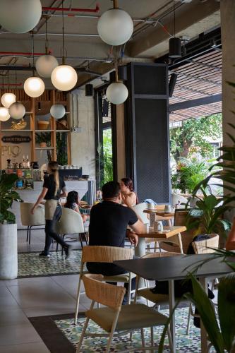 a group of people sitting at tables in a restaurant at Eutopiq Hotel in Medellín