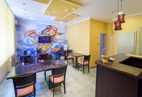 a dining room with a bar and a painting on the wall at Guest house Mali hotel in Subotica