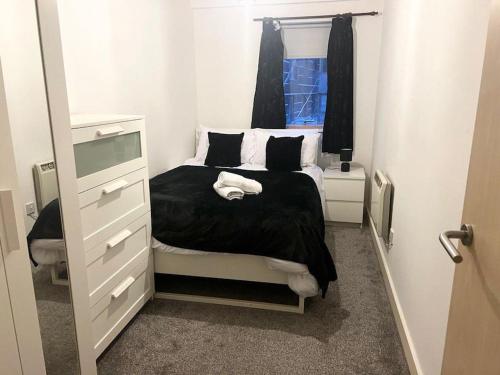 a bedroom with a bed and a dresser and a window at 2 Bedroom city center apartment in Manchester