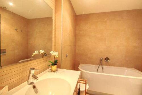 een badkamer met een bad, een wastafel en een bad bij Los Monteros Penthouse with Panoramic Sea View in Marbella