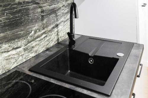 a black sink with a faucet on a counter at Apartamenty Różane in Laski
