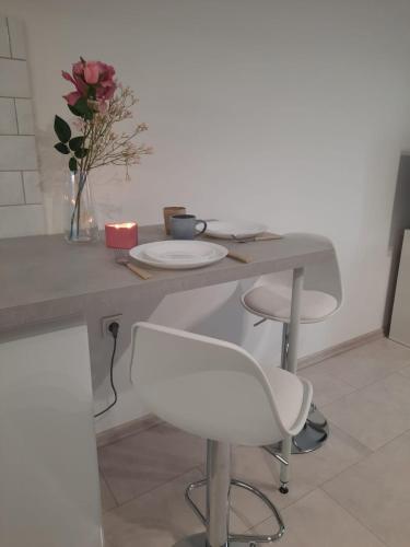a table with two chairs and a vase with flowers at Studio Violet blisko rynku in Kalisz