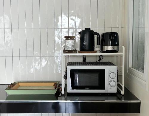 a microwave sitting on a counter in a kitchen at House near the beach in Nai Yang Beach