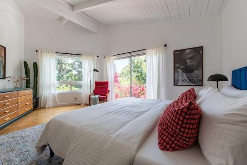 ein Schlafzimmer mit einem großen weißen Bett mit roten Kissen in der Unterkunft Stunning Hollywood Midcentury Modern-Views-Best Location! in Los Angeles
