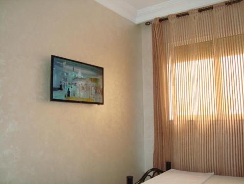 a television hanging on a wall in a bedroom at Silia Appartements in Temara