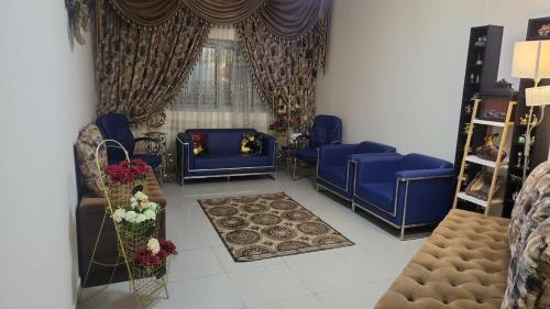 a living room with blue couches and a window at Daniel TRYP in Sharjah