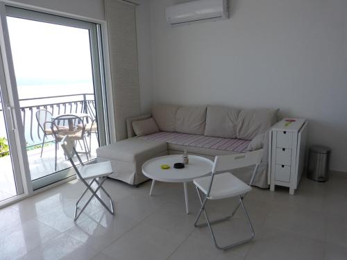 ein Wohnzimmer mit einem Sofa und einem Tisch sowie einem Balkon in der Unterkunft Apartment NoStress in Pisak
