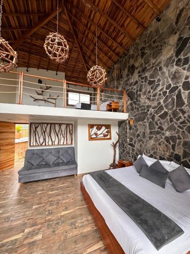 a bedroom with a bed and a stone wall at Hotel Campestre Palmas del Zamorano in San Gil