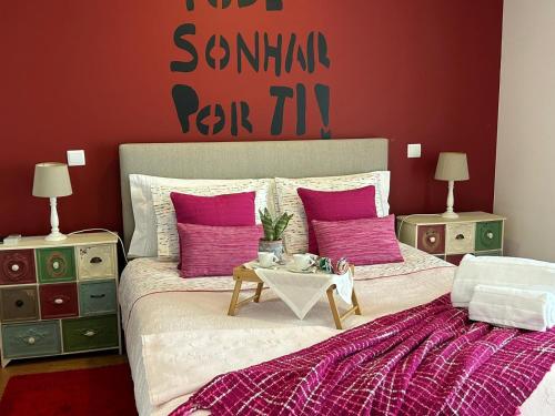a bedroom with two beds with pink pillows and a table at Fontainha House & SPA in Caldelas