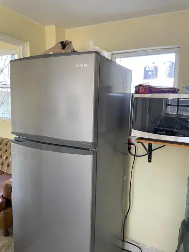 einen Kühlschrank mit einer Mikrowelle darüber in der Unterkunft Hostal Las Quince Letras in Tehuacán