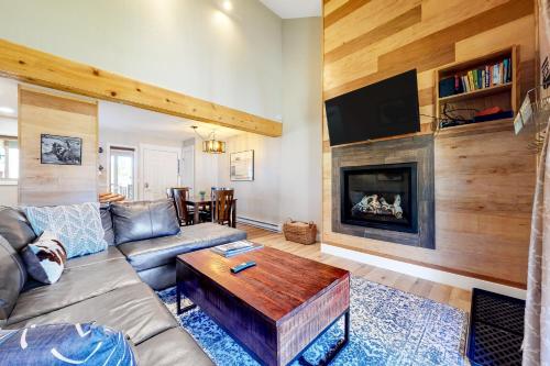 sala de estar con sofá y chimenea en Shadow Run Condos, en Steamboat Springs