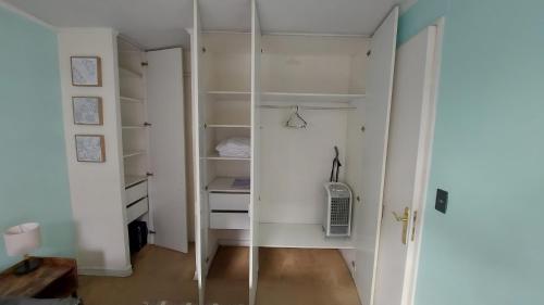 a walk in closet with white walls and shelves at Apartamento cómodo tranquilo Providencia in Santiago