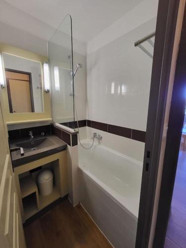 une salle de bain avec une baignoire, un lavabo et un miroir dans l'établissement Studio Cap Esterel By Sara, à Saint-Raphaël