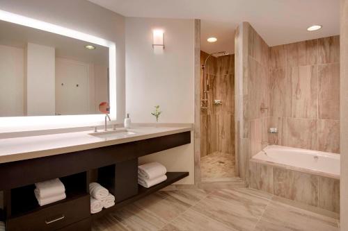 La salle de bains est pourvue d'un lavabo, d'une baignoire et d'une douche. dans l'établissement The Westin Dallas Park Central, à Dallas