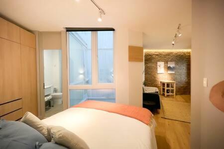 - une chambre avec un lit et une grande fenêtre dans l'établissement Hermoso Departamento en Lastarria 1D1B, à Santiago