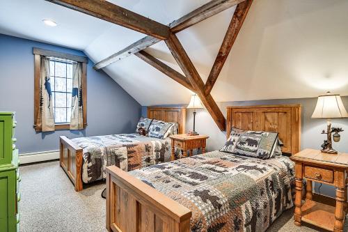 2 camas en un dormitorio con paredes azules y vigas de madera en Maine Home with Private Hot Tub and ATV Trail Access!, 