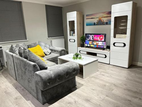 a living room with a couch and a tv at Luxury apartment in Slough FREE Parking near Heathrow, Legoland & Windsor Castle in Slough