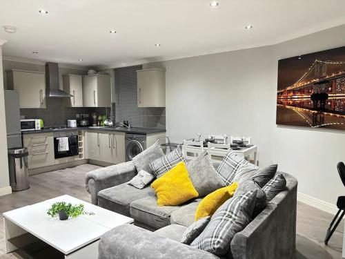 a living room with a couch and a kitchen at Luxury apartment in Slough FREE Parking near Heathrow, Legoland & Windsor Castle in Slough
