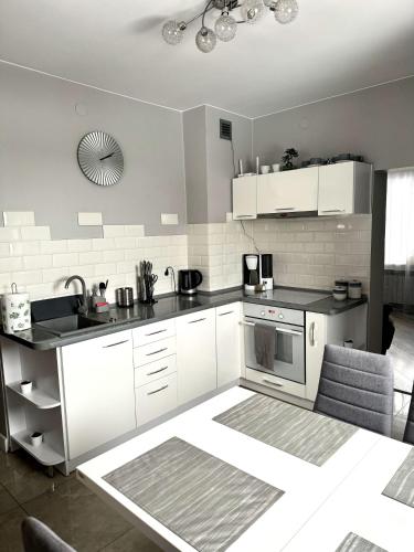 eine Küche mit weißen Schränken und einem Herd mit Backofen in der Unterkunft Domek u podnóża Skrzycznego in Lipowa