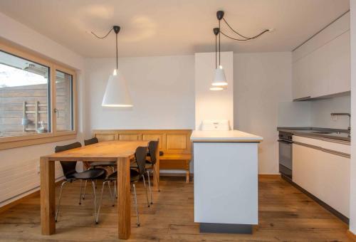 a kitchen and dining room with a table and chairs at Ferienwohnung Titschermatte in Adelboden