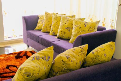 a purple couch with yellow pillows in a living room at Müller Hotel in Bella Vista