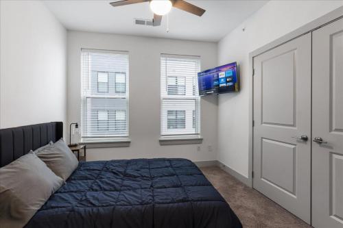 a bedroom with a bed and a flat screen tv at Charming 2BR 2BA Retreat near Downtown Cincinnati in Cincinnati