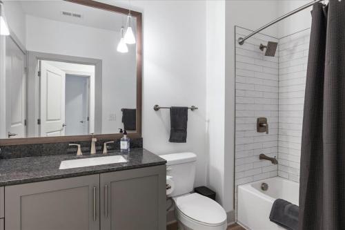uma casa de banho com um WC, um lavatório e um chuveiro em Charming 2BR 2BA Retreat near Downtown Cincinnati em Cincinnati