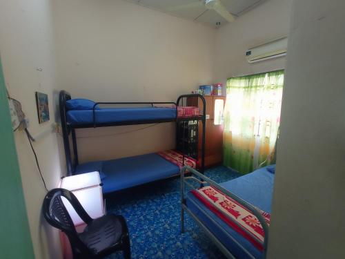 Pokój z 2 łóżkami piętrowymi w pokoju w obiekcie Homestay Melewar w mieście Parit Raja