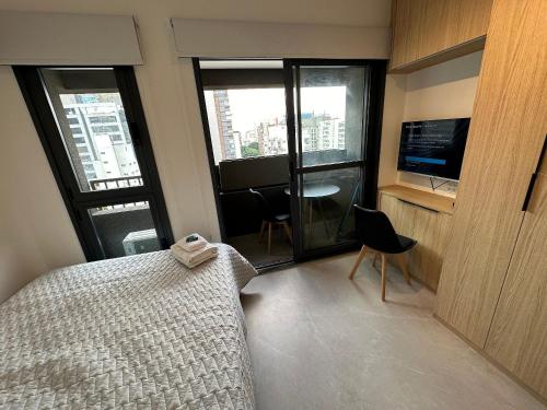 um quarto com uma cama, uma secretária e uma televisão em Studio Jardins Pamplona Cd 1310 em São Paulo
