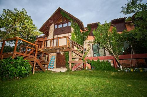 a large house with a deck and a yard at El vergel de la Sierra in Sierra de los Padres