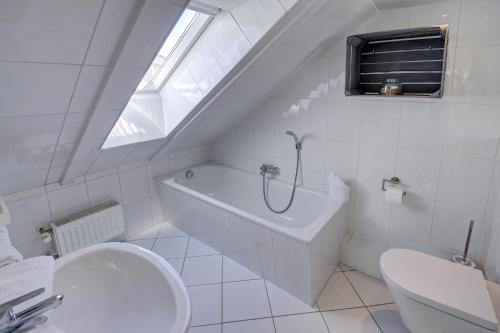 a white bathroom with a toilet and a sink at fewo1846 - Duenengras - elegante Maisonettewohnung mit 3 Schlafzimmern und Balkon in Schausende